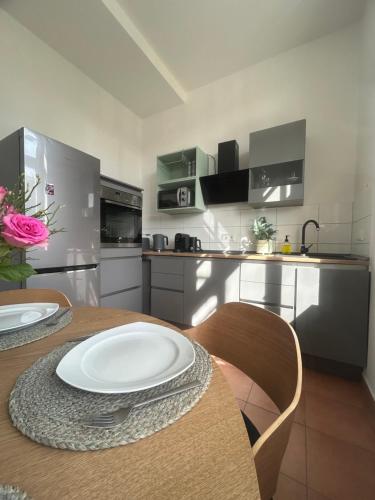 馬格德堡的住宿－Komfort Apartment mit Grill -Terrasse, Sky und Parkplatz，厨房配有一张桌子,上面有白色的盘子
