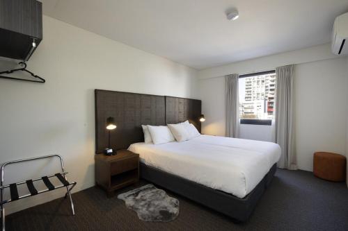 a hotel room with a bed and a television at East Perth CBD Apartment close to The Swan River in Perth