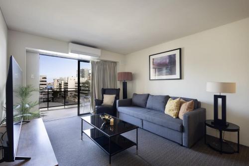 a living room with a couch and a glass table at East Perth CBD Apartment close to The Swan River in Perth