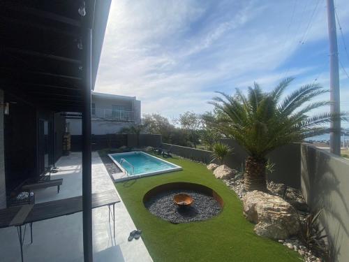 a backyard with a pool and a palm tree at ＩＲＡＧＯ　ＡＲＴ　 ＨＯＴＥＬ 　THECAPE in Irago
