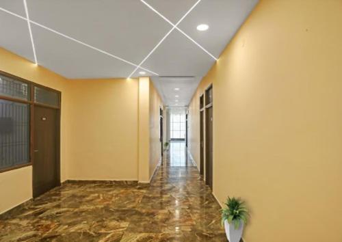 um corredor vazio com uma planta em vaso num edifício em S.B HOTEL em Kanpur