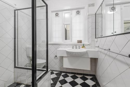 a white bathroom with a sink and a toilet at Elegant 1-Bed CBD Apartment with Sunroom Study in Melbourne