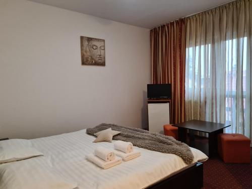 Una habitación de hotel con una cama con toallas. en Vila Șoimul Predeal en Predeal