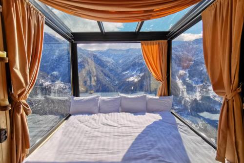 a bed in a room with a large window at Eco House Merisi in Merisi
