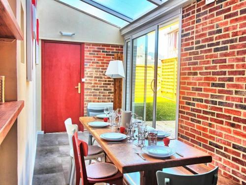 - une table en bois dans une chambre dotée d'un mur en briques dans l'établissement Belle Rive Comfortable holiday residence, à Veules-les-Roses