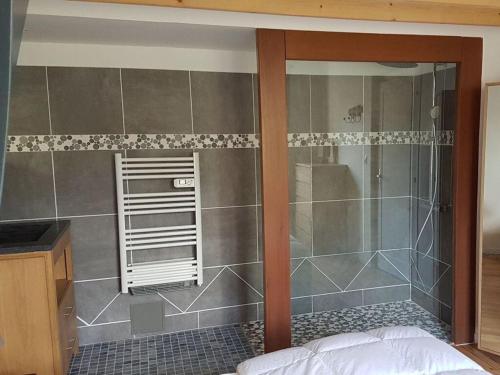 une douche avec une porte vitrée dans une salle de bain dans l'établissement Belle Rive Comfortable holiday residence, à Veules-les-Roses