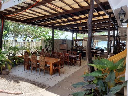 an outdoor patio with a wooden table and chairs at Yuken Mari Beach Resort Panglao in Panglao