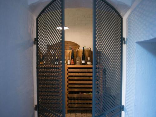 eine Tür zu einem Weinkeller mit einem Regal aus Weinflaschen in der Unterkunft Bergwiesen - Studio House 