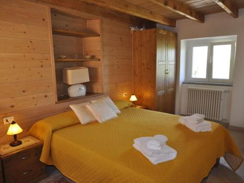 - une chambre avec un lit jaune et des serviettes dans l'établissement Casa Mariarosa Comfortable holiday residence, à Bugiallo
