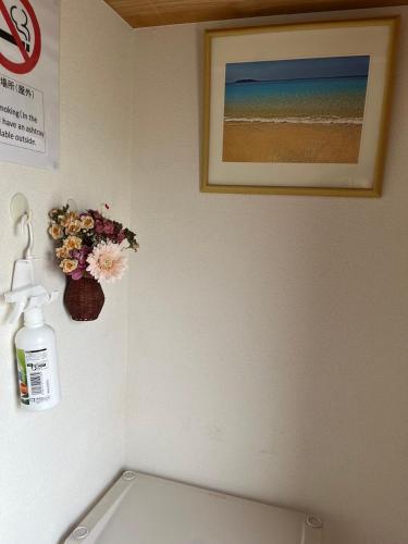 a bathroom with a sink and a flower on the wall at ばんぶ〜ハウス(BambooHouse) in Shimo-ōzu