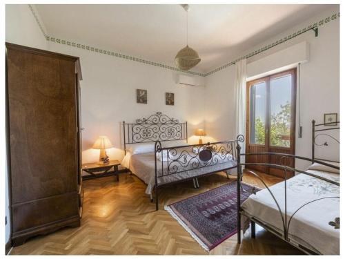 1 dormitorio con 2 camas y ventana en Villa Montecchio, en Cortona