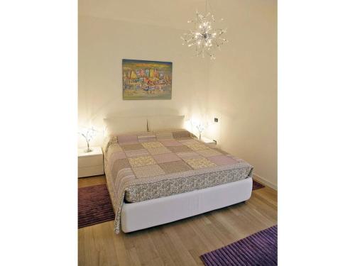 Schlafzimmer mit einem Bett und einem Kronleuchter in der Unterkunft le Camelie Comfortable holiday residence in Menaggio