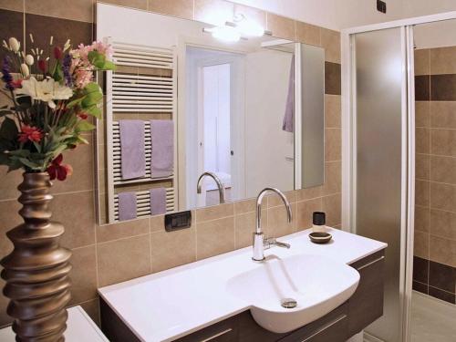 ein Badezimmer mit einem Waschbecken und einer Vase aus Blumen in der Unterkunft le Camelie Comfortable holiday residence in Menaggio