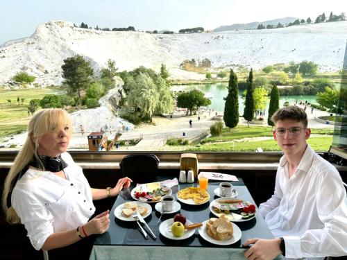 a man and a woman sitting at a table with breakfast at Pamukkale Sahin Boutique Hotel in Pamukkale