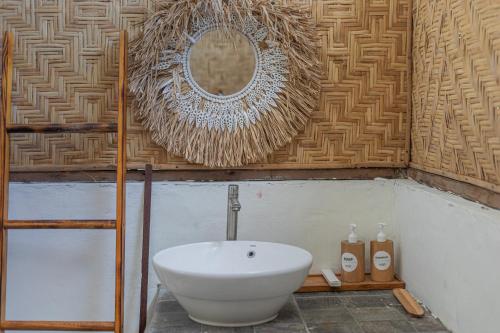 a bathroom with a sink and a mirror on a wall at Camani Glamping in Karangasem