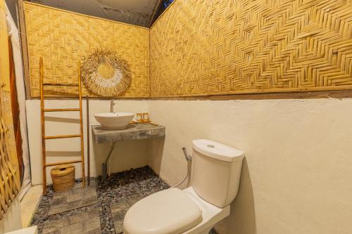 um banheiro com vaso sanitário e pia em Camani Glamping em Karangasem