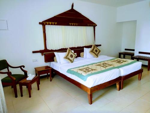 a bedroom with a large bed and a chair at Randholee Resort & Spa in Kandy