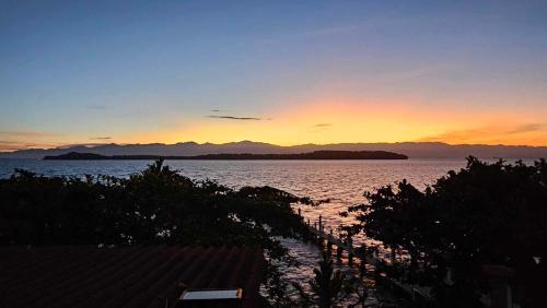 a sunset over a large body of water at Eagles Nest Beach Resort in Davao City