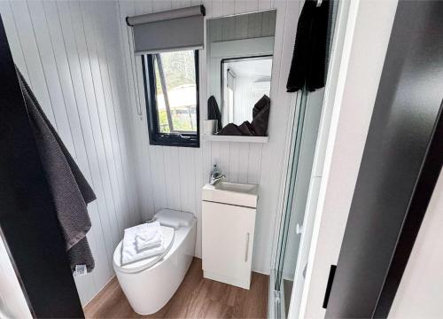 a small bathroom with a toilet and a mirror at Binderaga Old Orchard in Bilpin