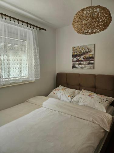 a bedroom with a bed and a chandelier at Apartman Noa in Knin