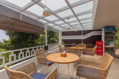 a patio with tables and chairs on a balcony at Munduk Kupang Sekumpul Villa in Singaraja