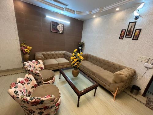 a living room with couches and chairs and a table at Divine India Service Apartment 3 BHK D-198 Saket in New Delhi