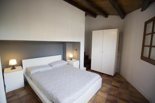 a bedroom with a white bed and two night stands at Mulino in Cefalù