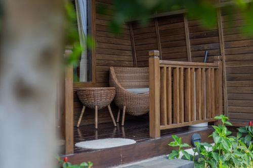 a porch with two chairs and a wooden fence at Munduk Kupang Sekumpul Villa in Singaraja
