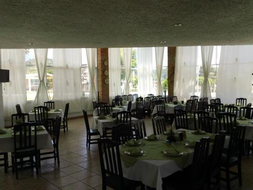 a room full of tables and chairs with white tablecloths at Hotel Villa Monarca Inn in Zitácuaro
