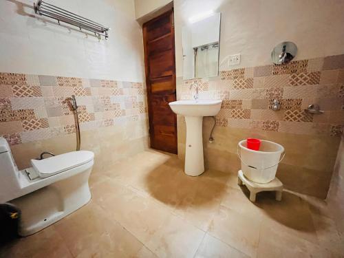 a bathroom with a sink and a toilet at Varsha Guest House in Vapi