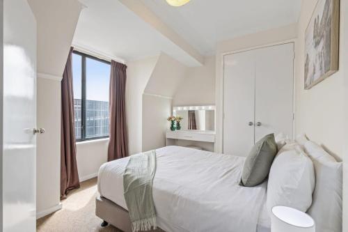 biała sypialnia z dużym łóżkiem i oknem w obiekcie East Perth Apartment with Free Wi-Fi and Parking w mieście Perth