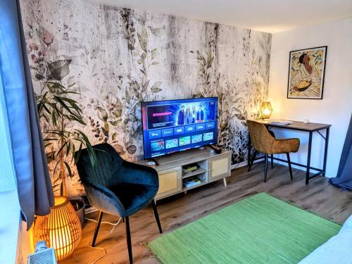 a living room with a television and a table at Uhlpartment - im Herzen von Salzwedel in Salzwedel