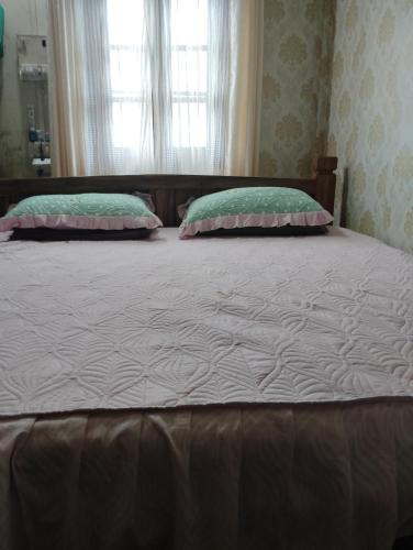 a large bed with two pillows in a bedroom at Aqhe Homestay in Kohīma