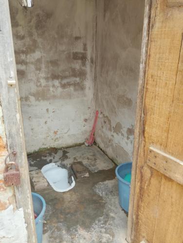 a dirty room with a bucket and a toilet at Aqhe Homestay in Kohīma