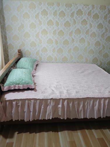 a bed in a bedroom with a wall at Aqhe Homestay in Kohīma