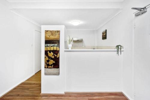 a white kitchen with white walls and a counter at Executive Apt - 2BR 1BA w Parking in Perth
