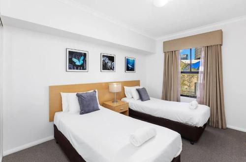 ein Hotelzimmer mit 2 Betten und einem Fenster in der Unterkunft Executive Apt - 2BR 1BA w Parking in Perth