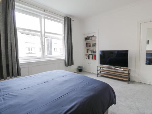 a bedroom with a bed and a flat screen tv at Little Ireland in Stranraer