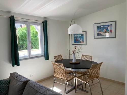 une salle à manger avec une table et des chaises noires dans l'établissement Un jardin dans la ville, à La Ciotat