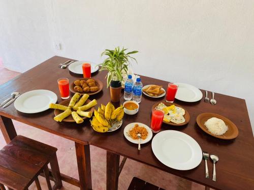 a wooden table with plates of food on it at TESHI SAFARI VILLA in Udawalawe