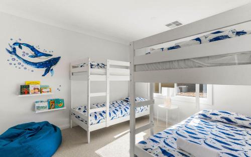 a bedroom with two bunk beds and a ladder at Beyond Beach House in Goolwa South