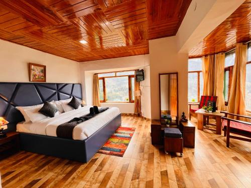 una camera con un grande letto e un soffitto in legno di Kamal Guest house a Vapi