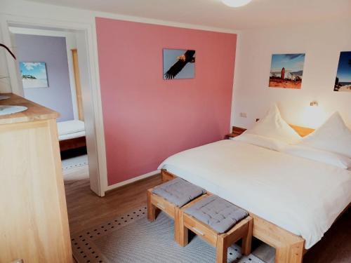 a bedroom with a white bed and a black cat on the wall at FeWo Seeadler - Heuser Prerow in Prerow