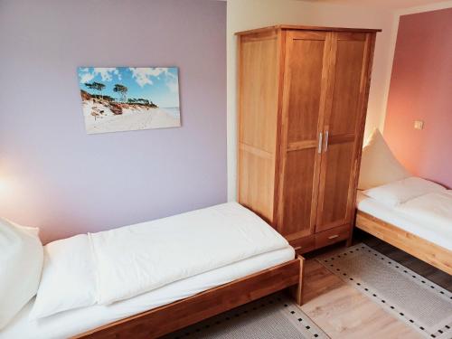 a small room with two beds and a cabinet at FeWo Seeadler - Heuser Prerow in Prerow
