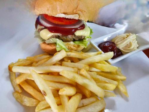 a hamburger and french fries on a plate at Eagles Nest Beach Resort in Davao City