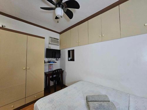 una camera con letto e ventilatore a soffitto di Eagles Nest Beach Resort a Davao