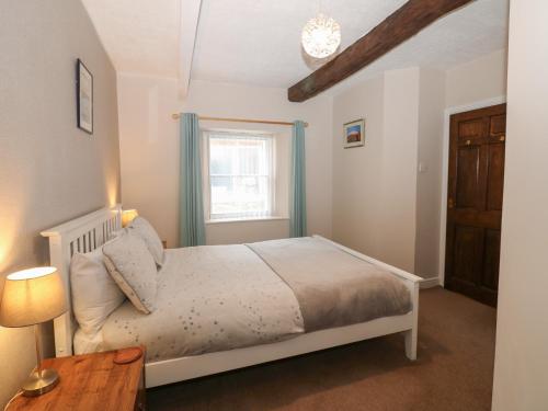 a bedroom with a white bed and a window at Oak Cottage in Appleby