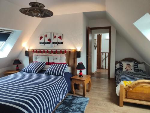 a bedroom with two beds and a ceiling at GÎTE DE LA FONTAINE in Wangen