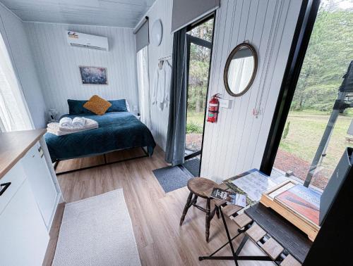 Dormitorio pequeño con cama y espejo en Binderaga Pine Forest en Bilpin