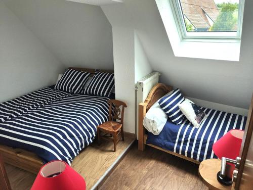 a small bedroom with two beds and a window at GÎTE DE LA FONTAINE in Wangen